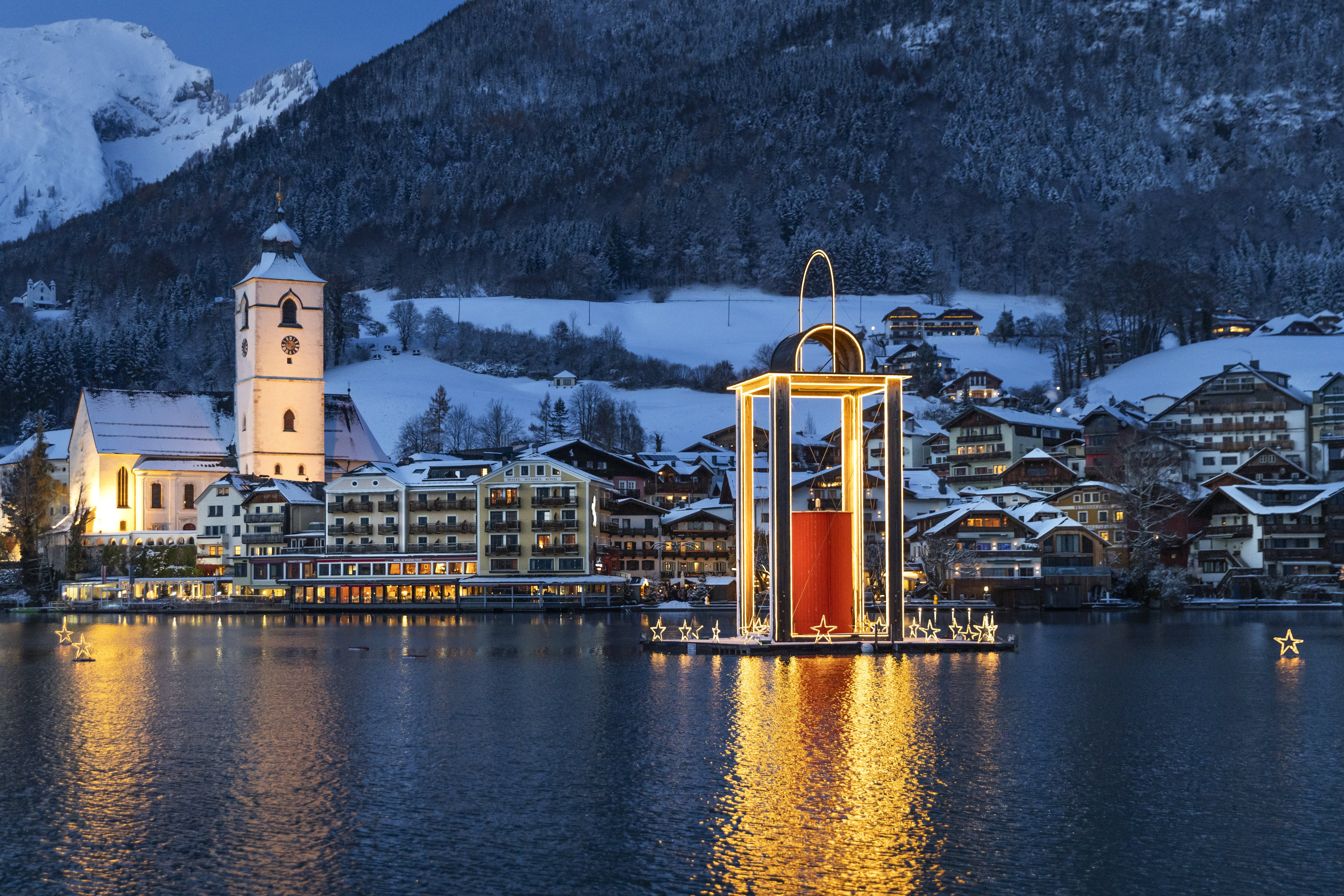 Winterwunder am Wolfgangsee Malersches Winterdorf mit Weihnachtslichtern und schneebedeckten Bergen am Seeufer