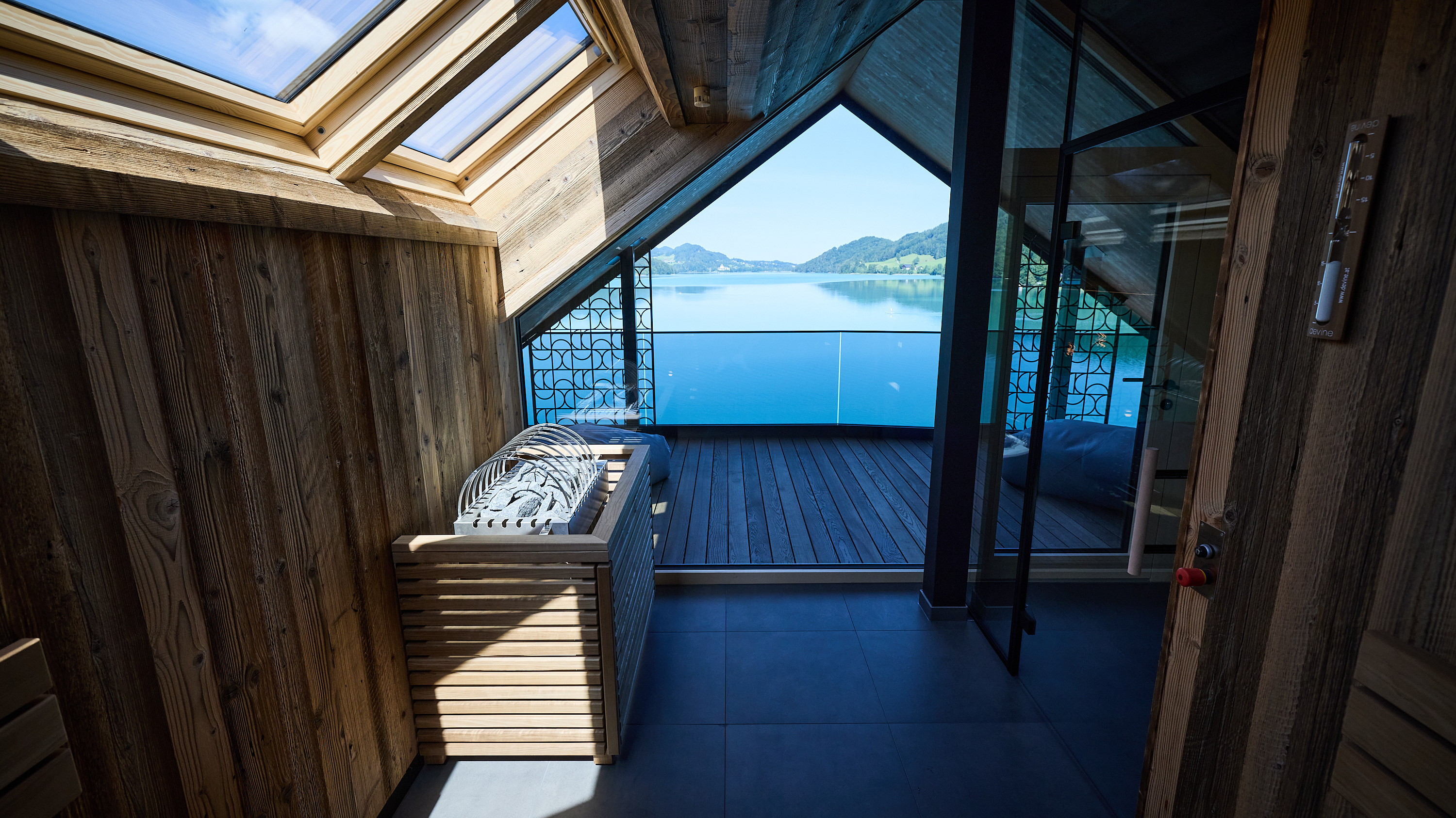 Interior space featuring wooden decor and large windows overlooking a lake view.