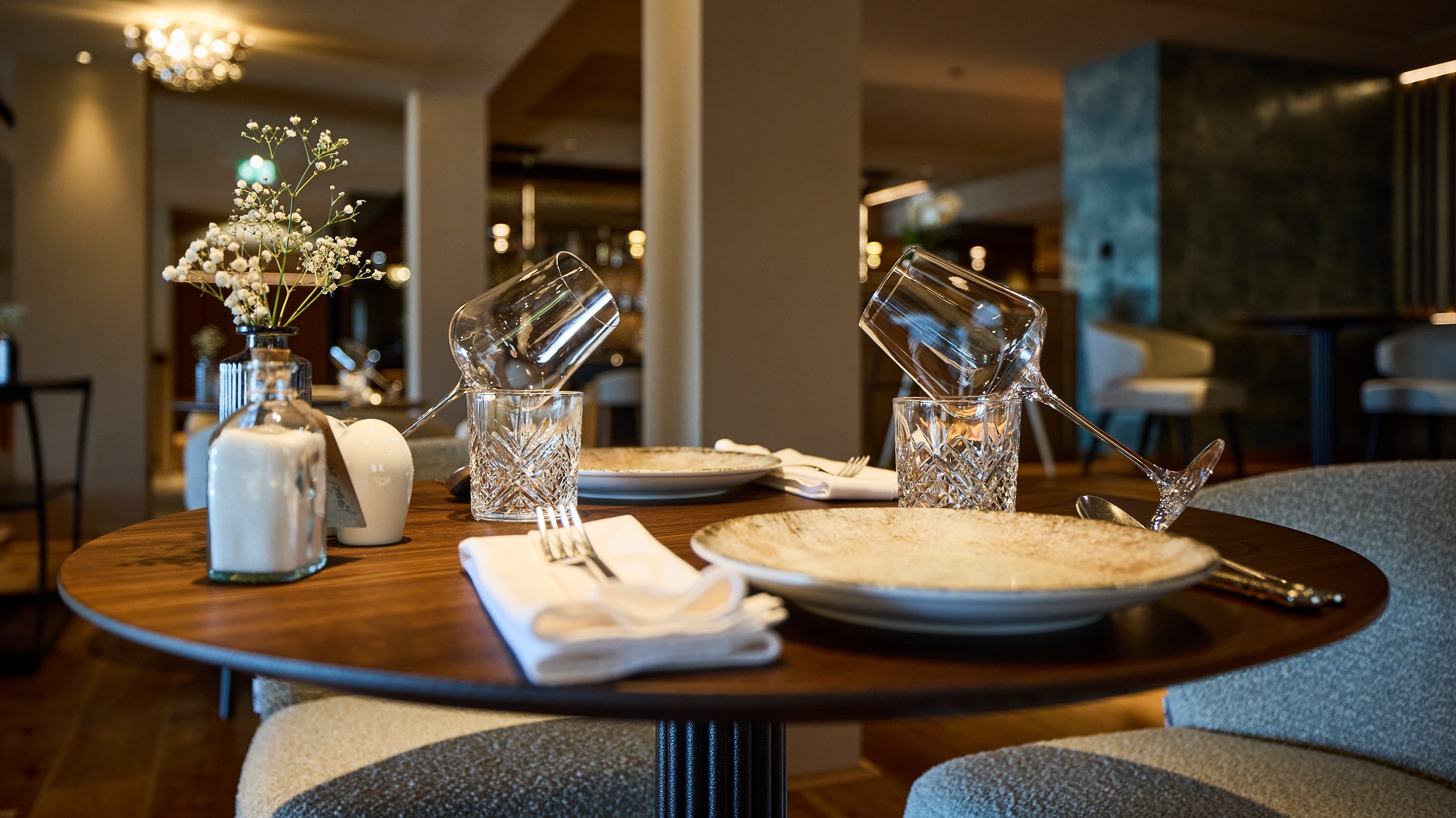 Eine stilvoll gedeckte Restauranttisch mit Glaswaren und Tellern für ein besonderes Dinner